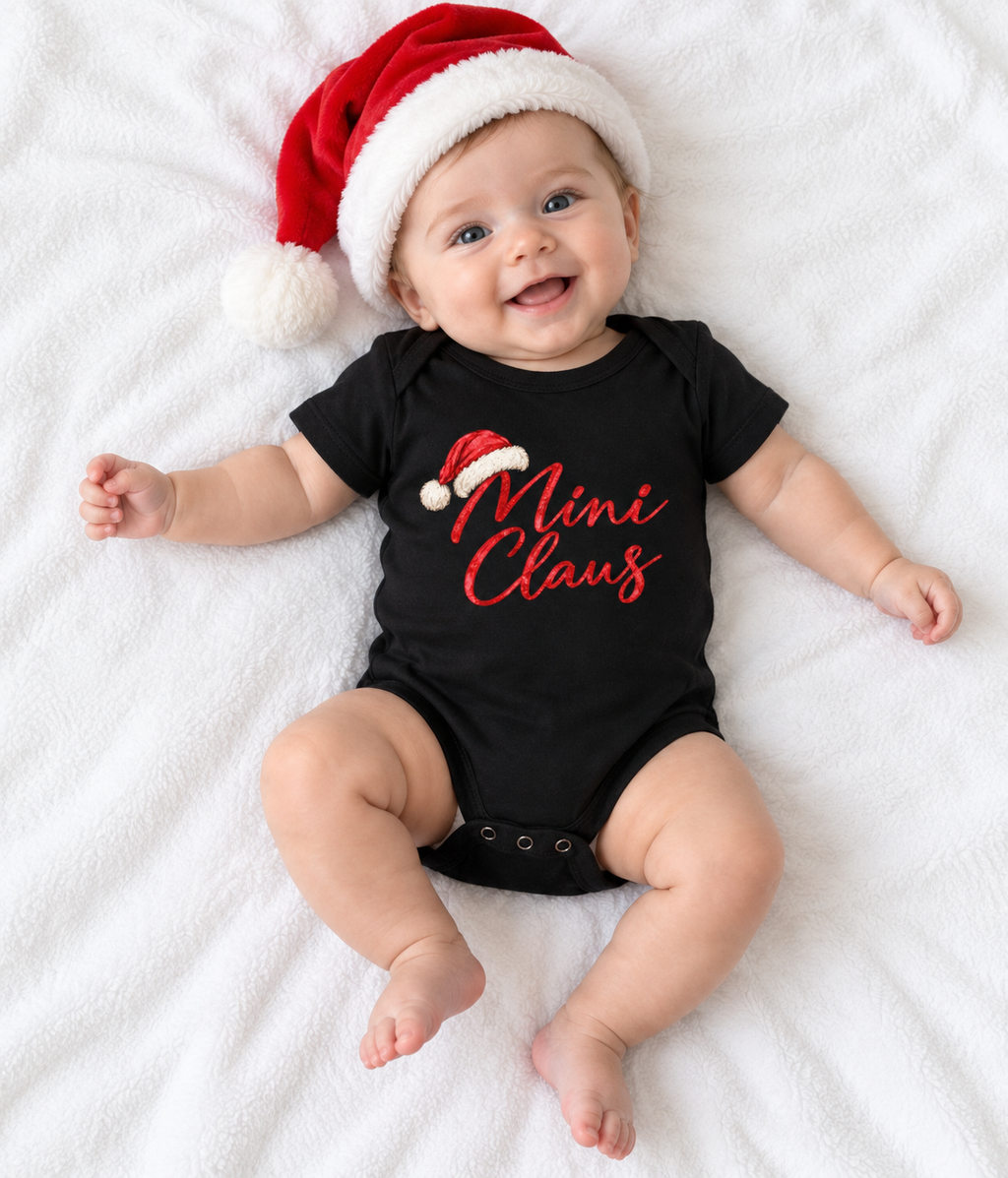 Baby wearing black Mini Claus bodysuit and Santa hat